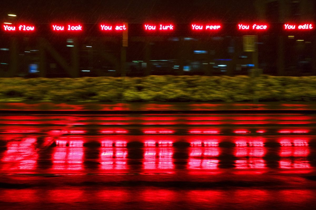 Panned shot reflecting the text onto a wet road